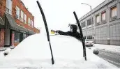  ?? Scott P. Yates / Associated Press ?? Joey Bell clears snow off his car Tuesday in Rockford, Ill. Many schools and businesses closed.