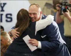  ?? JOHN BAZEMORE — THE ASSOCIATED PRESS ?? Newly hired Georgia Tech coach Geoff Collins gets a hug from a family member before speaking at a news conference on Friday in Atlanta.