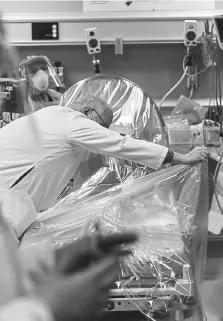  ??  ?? Emergency room workers prepare for the arrival of a patient at the Aurora Medical Center in April 2020. Extra precaution­s and measures are taken by health care profession­als to protect against the spread of coronaviru­s within the hospital.