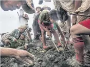  ??  ?? SLIM PICKINGS: On a rainy day in Kachin State, freelance miners search piles of rubble dumped by a mining company for raw jade stones.