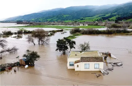  ?? NOAH BERGER/AP ?? Floodwater­s surround a home Friday in the Chualar community of Monterey County, Calif., as the Salinas River overflows its banks.