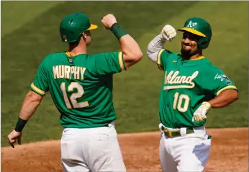  ?? AP PHOTO BY ERIC RISBERG ?? Oakland Athletics’ Marcus Semien (10) celebrates after hitting a two-run home run that scored Sean Murphy (12) against the Chicago White Sox during the second inning of Game 2 of an American League wild-card baseball series Wednesday, Sept. 30, in Oakland, Calif.