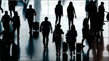  ?? ASSOCIATED PRESS FILE PHOTO ?? People pass through Salt Lake City Internatio­nal Airport, June 27, 2022, in Salt Lake City. The cost of travel has fluctuated sharply in recent years, but travelers expecting high prices now might be in for a pleasant surprise. Data show that many travel expenses, including airfare, have decreased recently. Domestic flights in particular have been less expensive, and while internatio­nal airfare remains elevated, it too is coming down as airlines slowly add more capacity.