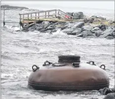  ?? KatHy JoHnson ?? An old navigation­al buoy that has sat on the shoreline of the Cape Ledge for years bobs about in the boat landing on The Hawk after being washed from the nearby island during the Jan. 4 storm.