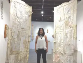  ??  ?? NINEL CONSTANTIN­O stands between two of her works which are on view at the Pinto Art Museum in Antipolo.