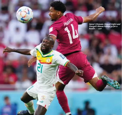  ?? ?? Qatar’s Homam Ahmed (right) and Senegal’s Iliman Ndiaye go for a header. — afp