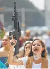  ?? Hector Vivas / Getty Images ?? A woman holding a fake gun shouts in Mexico City.