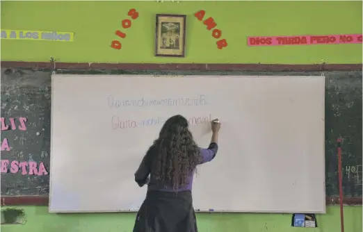  ?? MARTIN MEJIA/AP ?? Teacher Carmen Cazorla writes in the Quechua Indigenous language during a class on medicinal plants at a school in Licapa, Peru, last year.