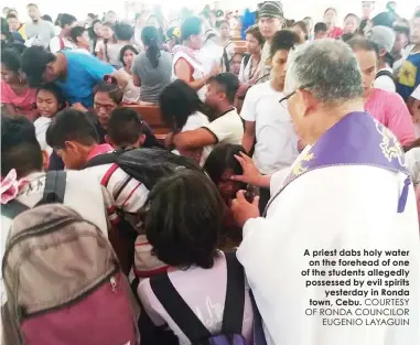  ?? COURTESY OF RONDA COUNCILOR
EUGENIO LAYAGUIN ?? A priest dabs holy wateron the forehead of one of the students allegedly possessed by evil spiritsyes­terday in Ronda town, Cebu.