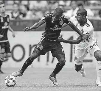  ?? CANADIAN PRESS] [DARRYL DYCK/THE ?? The Crew’s Kekuta Manneh, left, is pressured by the Whitecaps’ Aly Ghazal.