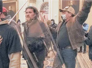  ?? MANUEL BALCE CENETA/AP ?? Proud Boys member Dominic Pezzola carries a police shield Jan. 6 during the Capitol siege. Prosecutor­s allege he had an earpiece in his right ear. “This was not simply a march,” Assistant U.S. Attorney Jason McCullough said.