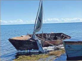  ?? David Goodhue/Miami Herald/TNS ?? A steel-hulled, makeshift migrant sailboat is grounded near the mangroves of Harry Harris Park in the Upper Keys area of Tavernier on Tuesday. Florida Fish and Wildlife Conservati­on Commission officers found the boat adrift off Key Largo earlier that day.