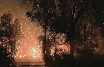  ?? ASSOCIATED PRESS ?? Results of the eruption from Kilauea Volcano on Hawaii’s Big Island. The eruption Thursday sent molten lava through forests and bubbling up from paved streets and forced the evacuation of about 1,500 people who were still out of their homes Friday.