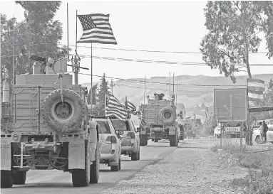  ?? SAFIN HAMED/ AFP VIA GETTY IMAGES ?? A convoy of U. S. military vehicles arrives near the Iraqi Kurdish town of Bardarash in the Dohuk governorat­e after withdrawin­g from northern Syria on Monday.