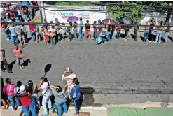  ??  ?? CIUDAD BOLIVAR: People queue outside a supermarke­t to buy basic food and household items, after massive lootings took place in Ciudad Bolivar, Bolivar state, Venezuela, on Monday. — AFP