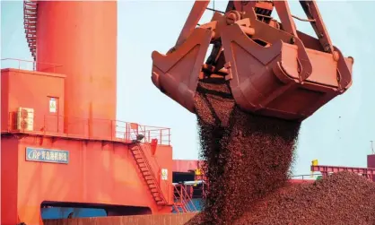  ?? Photograph: AFP via Getty Images ?? Iron ore is unloaded at a Chinese port. New customs rules could be used to block shipments of Australia’s most valuable export.