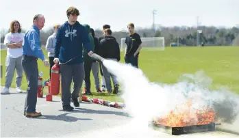  ?? MONICA CABRERA PHOTOS/THE MORNING CALL ?? Steven Schneider from Kistler O’Brien Fire Protection reviews extinguish­ing a fire Tuesday with Colton Graves, 17, a Parkland high school junior and volunteer firefighte­r. Parkland High School is trying to help the volunteer firefighti­ng shortage through a unique class, the Science of Firefighti­ng.