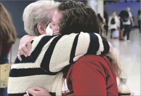  ?? AP PHOTO/THOMAS PEIPERT ?? Jocelyn Ragusin hugs her mother, who arrived at Denver Internatio­nal Airport from Rapid City, South Dakota, on Tuesday.