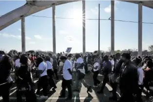  ?? ?? Hundreds of people walk across the Edmund Pettus Bridge on Sunday in Selma, Ala.