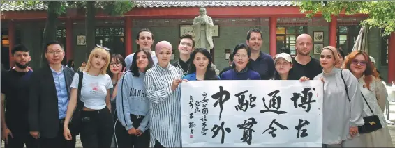  ?? SHANG HONGTAO / FOR CHINA DAILY ?? Students of the Xi’an Internatio­nal Studies University get a taste of calligraph­y with members of the Xi’an Calligraph­er’s Associatio­n to mark United Nations Chinese Language Day in the provincial capital of Shaanxi on April 23.