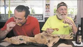  ?? Haley Nelson/Post-Gazette ?? Evan Wiesen, left, and Tom Horstman dine on wings Wednesday at Bigham Tavern on Mount Washington.