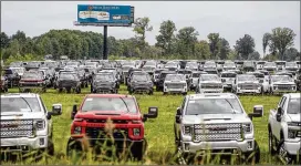  ?? JAKE MAY/FLINT JOURNAL VIA AP ?? Flint-built trucks sit parked in a vacant field off I-75 in September in Flint, Michigan. The Chevrolet Silverados and GMC Sierra pickups built at Flint Assembly are waiting for semiconduc­tors.