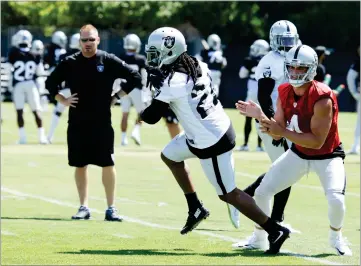 ?? AP PHOTO BY BEN MARGOT ?? Oakland Raiders quarterbac­k Derek Carr, right, hands the ball off to Marshawn Lynch during an NFL football training camp on Saturday, in Napa.