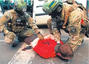  ?? Picture: AP. ?? Agents detain the suspect at a border crossing.