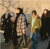  ?? ARASH KHAMOOSHI/THE NEW YORK TIMES ?? Women, including several wearing head coverings, walk Jan. 28 in Tehran, Iran.