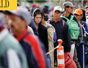  ?? GREGORY BULL/THE ASSOCIATED PRESS ?? Central American migrants wait in line for a meal at a shelter in Tijuana, Mexico, on Wednesday as the first sizable groups in the caravan fleeing violence in their home countries began arriving in the border city of Tijuana.