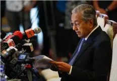  ??  ?? Malaysian Prime Minister Mahathir Mohamad reads a note during a press conference in Putrajaya. AP PhoTo/VIncenT ThIAn