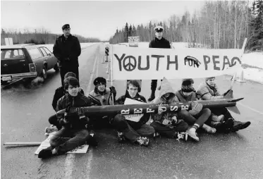  ??  ?? Cruise missile protesters sit on the highway in front of the military barricade near Cold Lake.