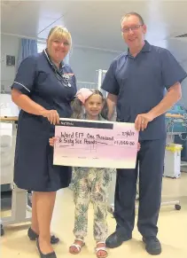  ??  ?? Pictured is Lucy Syrett-Barsby (centre) presenting the money raised by the fun day raffle to Ward E17 manager Michelle Kirkland and Roy Connell, the clinical nurse specialist for dialysis.