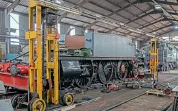  ?? ?? GWR 2-6-2T No. 4150, on road four inside the shed on the frame jacks with the superheate­r header belonging to No. 4930 prepared for testing on the right on August 13. Bulleid Pacific No. 34027 Taw Valley sits in the background.