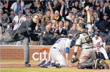  ?? AP ?? Home plate umpire Mike DiMuro calls the Cubs’ Nate Schierholt­z out at home as Pirates catcher Russell Martin shows DiMuro the ball.