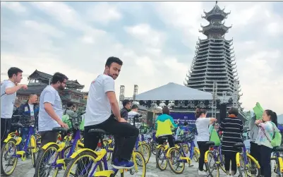  ?? DENG GANG / FOR CHINA DAILY ?? Foreign tourists ride shared bikes to China’s first ethnic-themed outdoor festival held in Rongjiang, Guizhou province, earlier this year. The festival involves a combinatio­n of sports and tourism with characteri­stics of Dong and Miao ethnic groups.