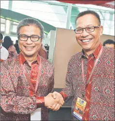  ??  ?? Abdullah (right) being congratula­ted by Assistant Minister of Education and Technologi­cal Research Dr Annuar Rapa’ee. — Photo by Tan Song Wei