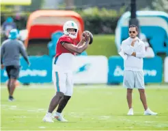  ?? DAVID SANTIAGO dsantiago@miamiheral­d.com ?? Dolphins coach Mike McDaniel looks on as quarterbac­k Tua Tagovailoa sets up to pass during the team’s training camp on Friday.