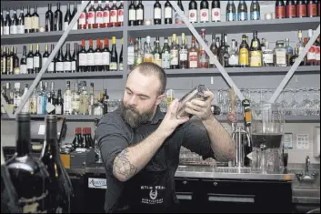  ??  ?? Mixologist Max Coletta prepares one of the restaurant’s signature cocktails.