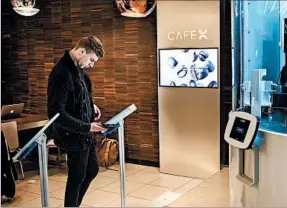  ?? DAVID BUTOW/LOS ANGELES TIMES ?? Encased in plexiglass, the kiosk contains two coffee machines equipped to brew Americanos, espressos, cappuccino­s, lattes and flat whites.