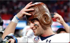  ?? AP/JOHN BAZEMORE ?? Auburn quarterbac­k Jarrett Stidham tries on the “Old Leather Helmet” after the No. 9 Tigers defeated No. 6 Washington 21-16 on Saturday in Atlanta. Stidham was 26-of-36 passing for 273 yards and 1 touchdown for the Tigers.