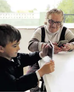  ?? FRANK PALACE ?? Una abuela y su nieto, en Castellón, consultand­o sus dispositiv­os.