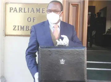  ??  ?? Finance and Economic Developmen­t Minister Professor Mthuli Ncube poses for a picture outside the Parliament building ahead of the 2021 Mid-Term Budget and Economic Review Speech in Harare yesterday