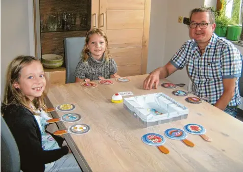  ?? Foto: Bianca Kattai ?? Die Familie Kattai aus Offingen liebt Spielabend­e. Für unsere Zeitung testeten Emma (links) und Marie mit Papa Michael „Pfannen Pannen“. Zusammen mit Mama Bianca ging es dabei lustig zu.