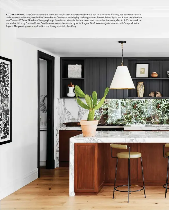  ??  ?? KITCHEN/DINING The Calacatta marble in the existing kitchen was retained by Katie but treated very differentl­y. It’s now teamed with walnut-veneer cabinetry, installed by Simon Paton Cabinetry, and display shelving painted Porter’s Paints Squid Ink. Above the island are two Thomas O’Brien ‘Goodman’ hanging lamps from Laura Kincade. Iva bar stools with custom leather seats, Grazia & Co. Artwork on the wall at left is by Graeme Rowe. Smaller artworks on shelves are by Katie Sargent (left), Alannah Josie (centre) and Campbell Irvine (right). The painting on the wall behind the dining table is by Zoe Grey.