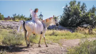  ??  ?? ABOVE: Theresa Falzone, dressed as a fairy, rides the unicorn Zeema at the Santa Fe Renaissanc­e Faire.