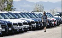  ?? DAVID ZALUBOWSKI / ASSOCIATED PRESS ?? A lot technician passes by a long line of unsold 2018 and 2019 Countryman models in August at a Mini dealership in Highlands Ranch, Colo.