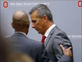  ?? PAUL VERNON — THE ASSOCIATED PRESS ?? Ohio State University President Michael Drake and football coach Urban Meyer leave the stage following a news conference Aug. 22 in Columbus.