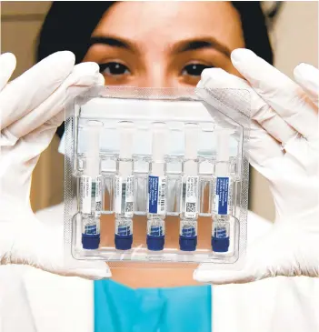  ?? KIM HAIRSTON/THE BALTIMORE SUN ?? Nurse practition­er Behishta Ishanzai on Tuesday with single dose vials of the 2021-2022 formula of the influenza vaccine at the MinuteClin­ic at the CVS drug store in Harbor East in Baltimore.