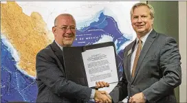  ?? ALYSSA POINTER / ALYSSA.POINTER@AJC.COM ?? Francisco Javier Diaz De Leon (left) and Tom C. Rawlings signed a memorandum of understand­ing Wednesday to help immigrant kids.